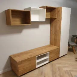 Nowoczesna zabudowa meblowa z szafkami wiszącymi i szafą stojącą, wykończona w bieli i dekorze drewna, na tle szarej ściany i parkietu w jodełkę.