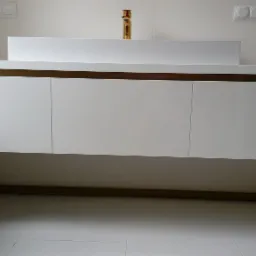 Biała szafka łazienkowa pod umywalkę z trzema frontami, na złotych metalowych nogach, z widoczną złotą baterią umywalkową na tle białych płytek.