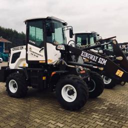 Kingwaymaszyny.pl - Rząd nowych, białych i czarnych maszyn budowlanych Kingway SZM z białymi felgami, stojących na brukowanym placu, widocznych z boku.