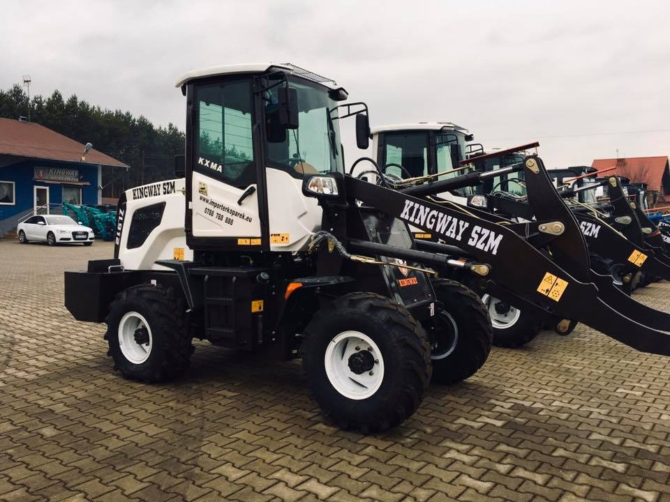 Rząd nowych, białych i czarnych maszyn budowlanych Kingway SZM z białymi felgami, stojących na brukowanym placu, widocznych z boku.