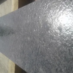 Szlifowany, grafitowy blat kamienny z widoczną fakturą, oparty o drewnianą konstrukcję.