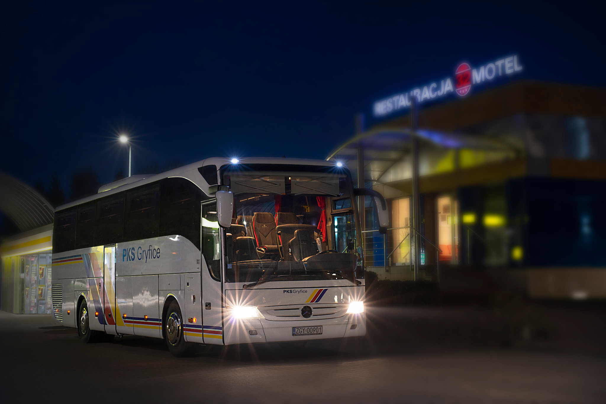 Autokar PKS Gryfice z otwartymi drzwiami stoi nocą przed budynkiem z napisem RESTAURACJA MOTEL.