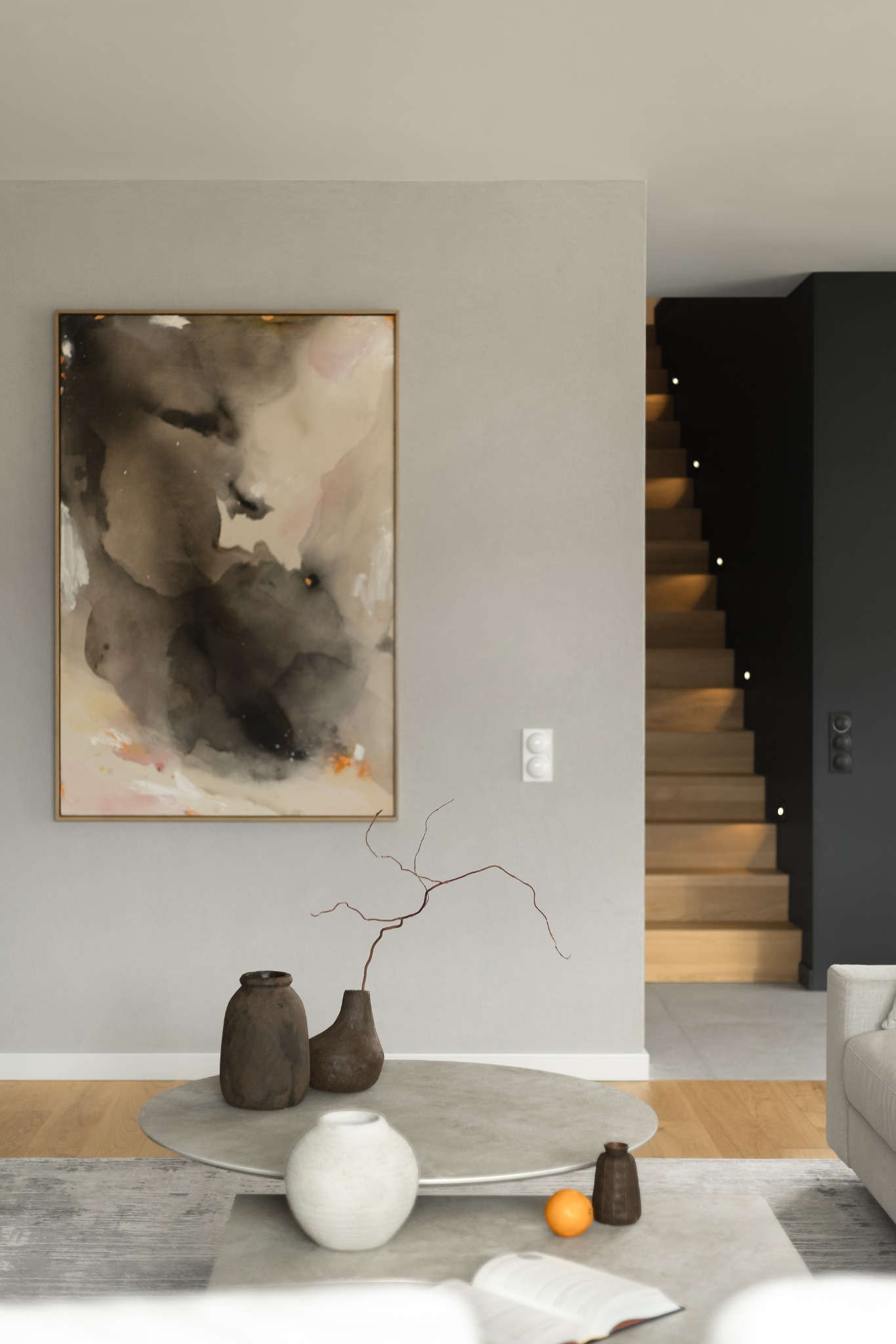 Stylowy salon z obrazem abstrakcyjnym i elementami dekoracyjnymi, schody z punktowym oświetleniem w tle. Minimalistyczny design wnętrza.