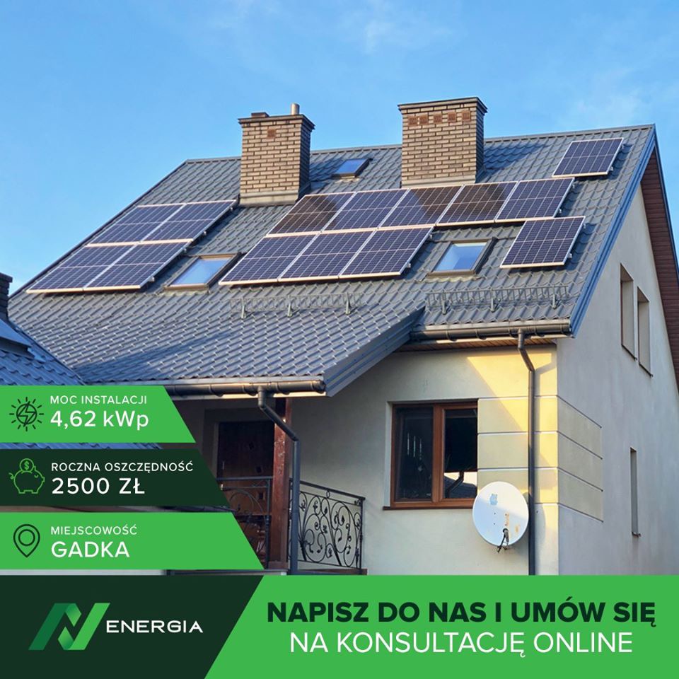 Dom jednorodzinny z szarą dachówką, na której zamontowano panele słoneczne. Widoczne dwa kominy z cegły oraz okna dachowe. Grafika reklamowa informuje o mocy instalacji 4,62 kWp oraz rocznej...