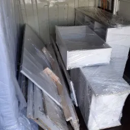 Meble owinięte folią stretch załadowane w przestrzeni ładunkowej dostawczego samochodu.