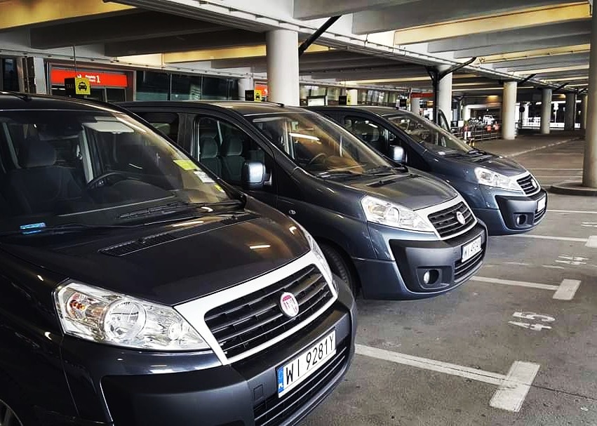 Trzy szare busy Fiat Scudo zaparkowane w rzędzie na parkingu podziemnym, widoczne tablice rejestracyjne z Polski.