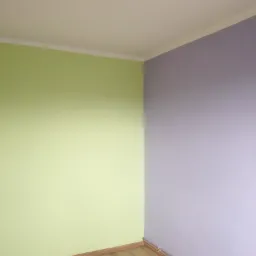 Pomieszczenie po malowaniu, z jedną ścianą w odcieniu zieleni i drugą w fioletowym, listwy przypodłogowe częściowo zamontowane, widoczne fragmenty paneli podłogowych.