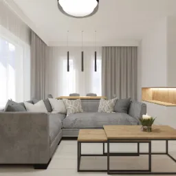 Nowoczesny salon z narożną sofą w odcieniach szarości, drewnianymi stolikami kawowymi i oświetloną wnęką ścienną, uzupełniony o minimalistyczne lampy wiszące i schody z czarną balustradą.