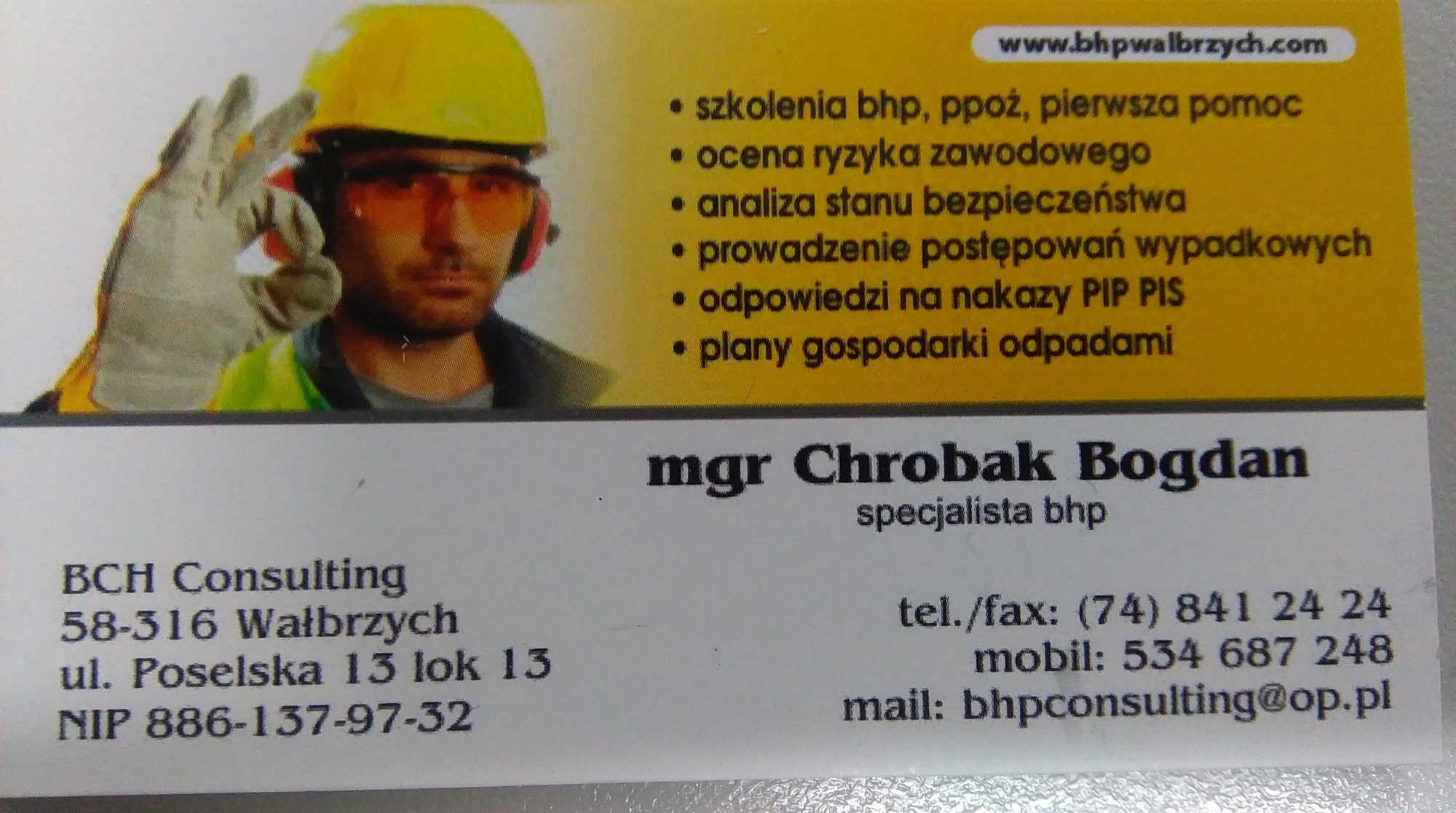 Wizytówka z wizerunkiem specjalisty w kasku i okularach ochronnych, prezentująca ofertę usług z zakresu bezpieczeństwa i higieny pracy, w tym szkolenia i ocena ryzyka zawodowego.