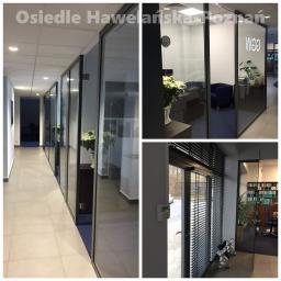 Perfect Windows Glazing Excellence - Przeszklone ściany działowe z czarnymi ramami tworzące biura w biurowcu Osiedle Hawelańska Poznań, widok z korytarza, detale wnętrza biur widoczne przez szkło.