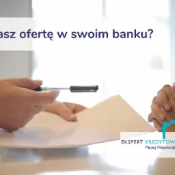 Osoba podaje dokument do podpisu długopisem, w tle złożone ręce, logo eksperta kredytowego w rogu.