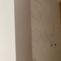 mykola katruk - Fragment ściany z efektem marmuru, widoczne dwa otwory na gniazdka elektryczne przed malowaniem, z lewej strony widoczny fragment narożnika.