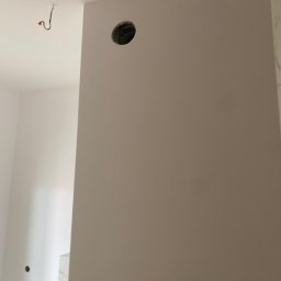 mykola katruk - Przygotowana ściana we Wrocławiu, z wywierconym otworem na instalację, świeżo po nałożeniu gładzi szpachlowej.