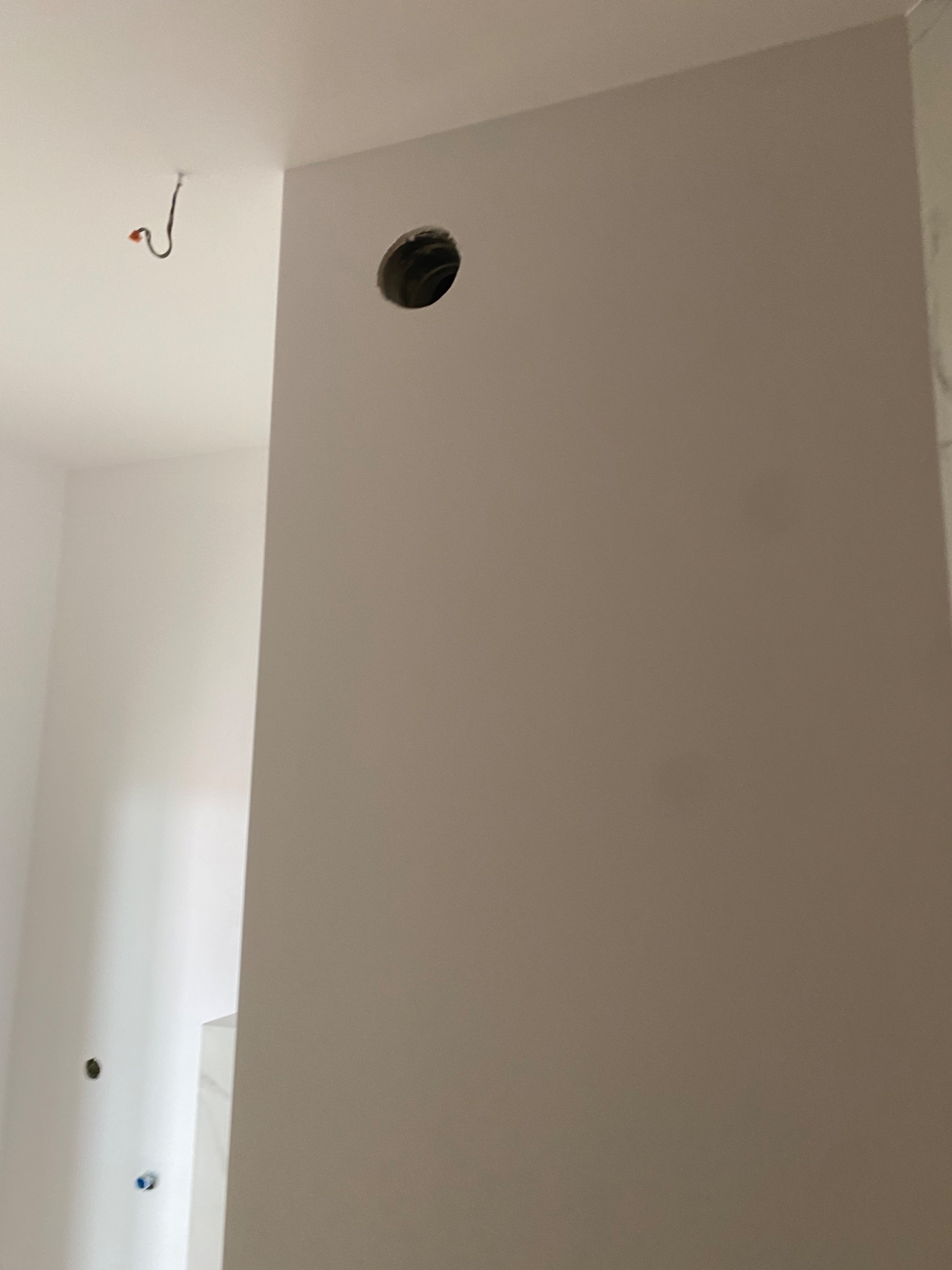 Przygotowana ściana we Wrocławiu, z wywierconym otworem na instalację, świeżo po nałożeniu gładzi szpachlowej.