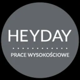 Szare okrągłe logo firmy HEYDAY z białym napisem 'HEYDAY' i 'PRACE WYSOKOŚCIOWE' oddzielonymi rzędem kropek.