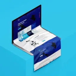 Laptop wyświetlający projekt strony internetowej o tematyce nanotechnologii, z efektem wychodzenia projektu poza ekran na niebieskim tle.