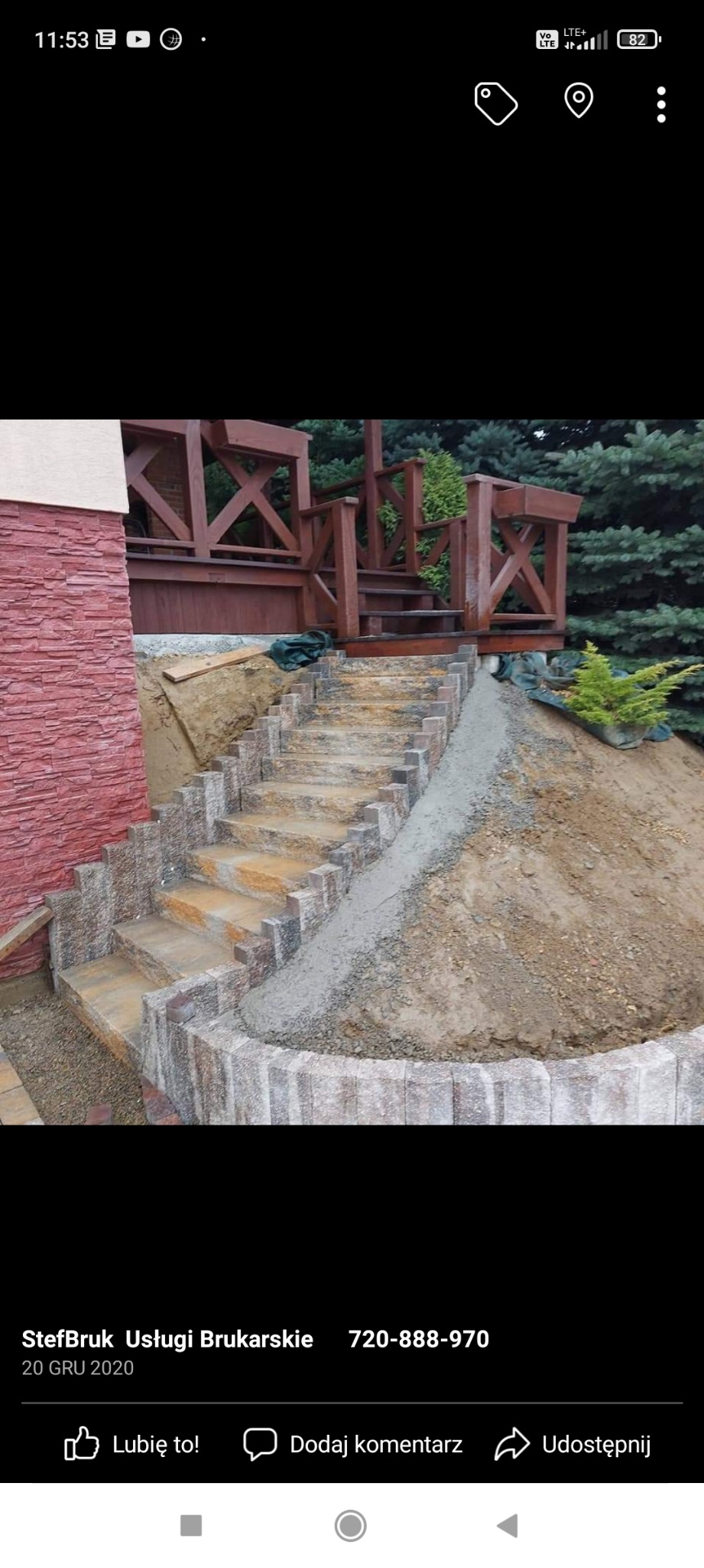 Kamienne schody prowadzące do drewnianej konstrukcji, częściowo wykończone, z widocznym obrzeżem z kostki i świeżym betonem, na tle zieleni.