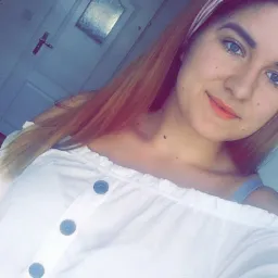 Portret młodej kobiety z opaską we włosach, ubrana w białą bluzkę z guzikami, na tle białych drzwi z szybką.