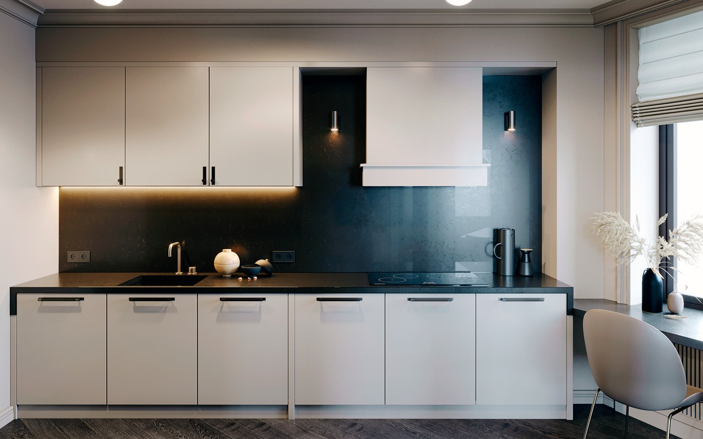 Minimalistyczna kuchnia z szarymi szafkami, czarnym blatem i ścianą, oświetleniem LED pod szafkami wiszącymi i dekoracjami na blacie, w tym wazonem z suszonymi trawami przy oknie.