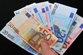 Stos banknotów euro o różnych nominałach (50, 20, 10) trzymany w dłoni na czarnym tle w miejscowości roma.