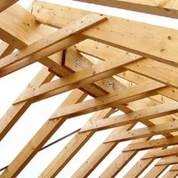 Konstrukcja drewniana dachu z jasnego drewna, widoczne elementy mocujące i wzmocnienia.