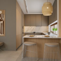 MW Projekt Studio. Projektowanie Wnętrz Monika Wachowiak - Nowoczesna kuchnia w odcieniach beżu i szarości z marmurowym blatem, oświetleniem LED i rattanową lampą. Na ścianie obraz w stylu retro i minimalistyczny taboret.