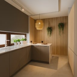 MW Projekt Studio. Projektowanie Wnętrz Monika Wachowiak - Nowoczesna kuchnia z brązowymi szafkami, marmurowym blatem, drewnianą ścianą i wiszącymi roślinami. Oświetlenie punktowe i dekoracyjna lampa nad wyspą.