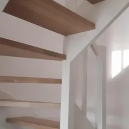 Drewniane schody wiszące z białymi balustradami, widok z dołu, minimalistyczny design.