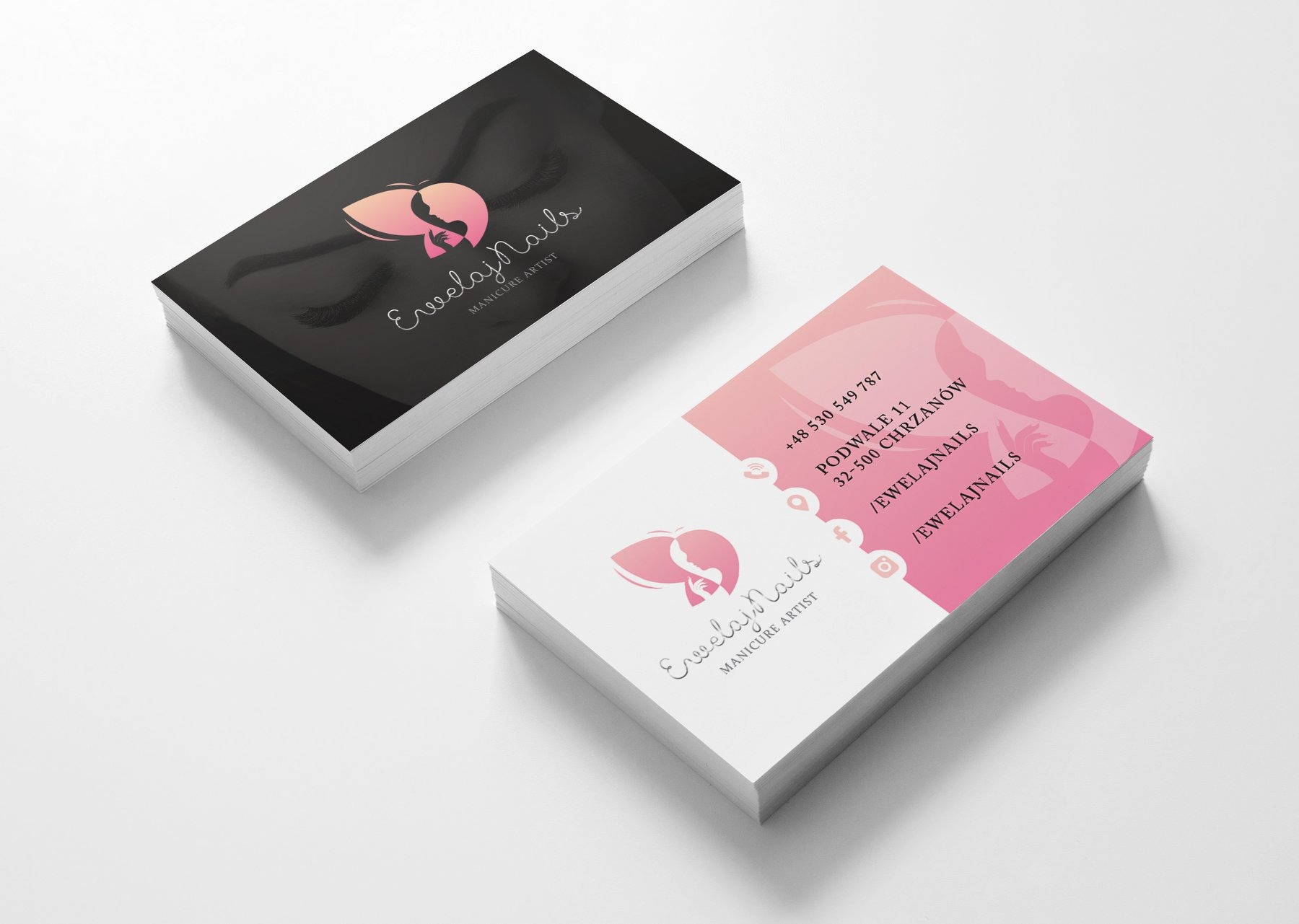 Dwa stosy wizytówek z logo i danymi kontaktowymi manicure artist, na białym tle. Jeden stos czarny z grafiką twarzy w profilu, drugi biało-różowy z numerem telefonu, adresem i ikonami mediów...