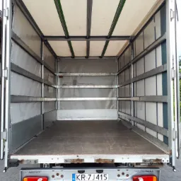 Wnętrze pustej przestrzeni ładunkowej samochodu dostawczego Renault Master z otwartymi drzwiami, gotowego do załadunku w Sieprawiu. Widoczna tablica rejestracyjna KR 7J415.