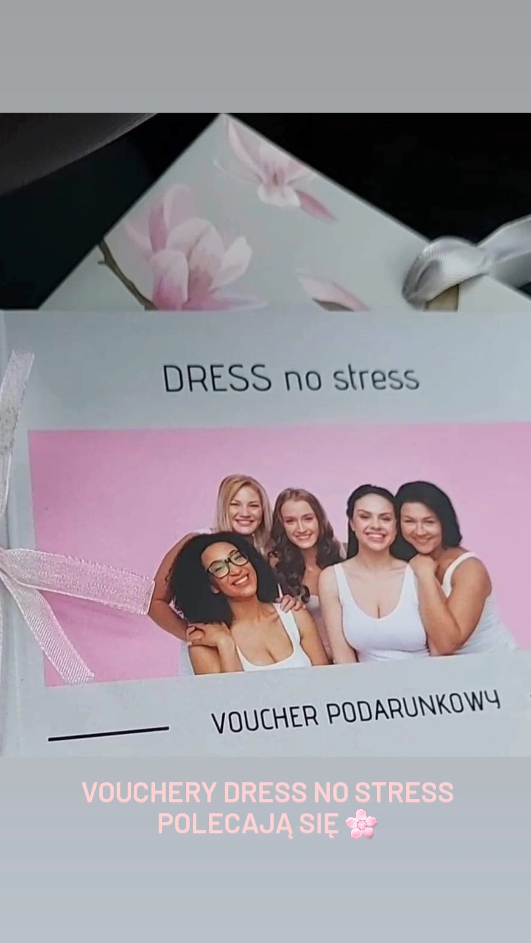 Voucher podarunkowy 'Dress no stress' z grafiką pięciu uśmiechniętych kobiet w białych topach, ozdobiony białą wstążką.