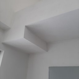 Marcin Owczarek - roboty ogólnobudowlane - Białe ściany i sufit z nietypową konstrukcją architektoniczną, świeżo po malowaniu, z widoczną fakturą powierzchni.