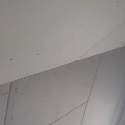 Poddasze w Grzybnie z płyt gipsowo-kartonowych, widoczne łączenia płyt i ślady po wkrętach, przygotowane do dalszych prac wykończeniowych.