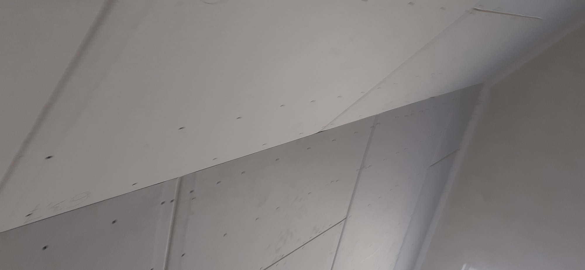 Poddasze w Grzybnie z płyt gipsowo-kartonowych, widoczne łączenia płyt i ślady po wkrętach, przygotowane do dalszych prac wykończeniowych.