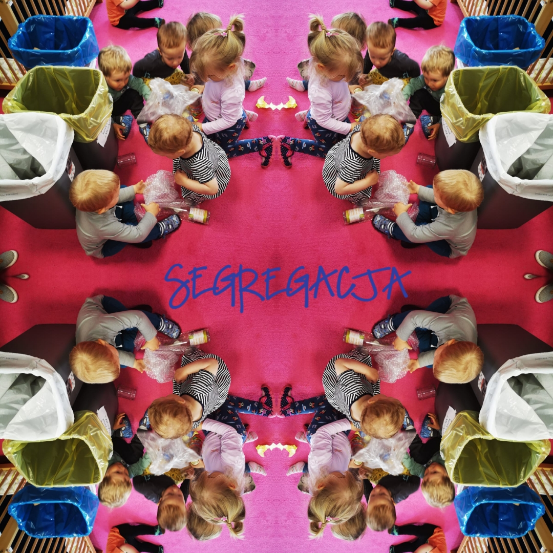 Fotografia przedstawia dzieci w żłobku siedzące na różowym dywanie i segregujące śmieci do kolorowych pojemników; widoczny napis 'SEGREGACJA'.