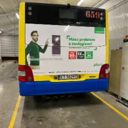 Tylna ściana autobusu miejskiego z reklamą sieci Plus z hasłem 'Masz problem z zasięgiem?' i zdjęciem smartfona Samsung Galaxy S20, numer linii 659.