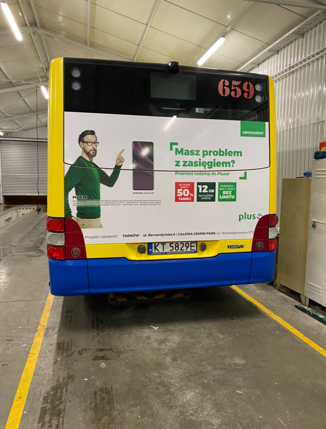 Tylna ściana autobusu miejskiego z reklamą sieci Plus z hasłem 'Masz problem z zasięgiem?' i zdjęciem smartfona Samsung Galaxy S20, numer linii 659.