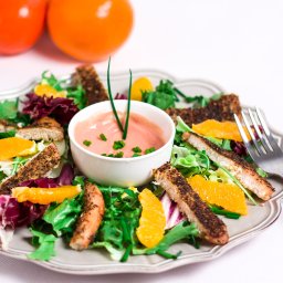 Craftshots - fotografia wnętrz, kulinarna, reklamowa. - Sałatka z grillowanym kurczakiem, pomarańczami i różowym sosem w białej miseczce, udekorowana szczypiorkiem, podana na ozdobnym talerzu z widelcem.