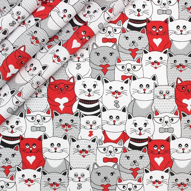 Wzór tkaniny z motywem stylizowanych kotów w odcieniach bieli, szarości i czerwieni, niektóre z sercami, muszkami i okularami.