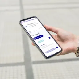 Kobieta trzyma smartfon z otwartą aplikacją Prawnik.App, wyświetlającą strefę klienta z poradami i informacjami o płatnościach. Widoczny jest fragment srebrnego zegarka na nadgarstku.
