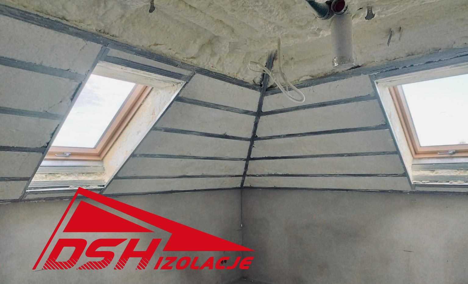 Poddasze z oknami dachowymi po izolacji pianką PUR, widoczne metalowe profile i fragment instalacji. Logo firmy w lewym dolnym rogu.