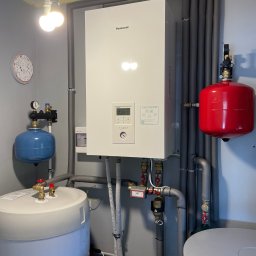 Modernizacja kotłowni w miejscowości Chrząstawa Mała. Panasonic 9 kW 3f ogrzewa dom i ciepłą wodę. Dodatkowo bufor jest zasilany kominkiem z płaszczem wodnym. 