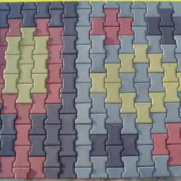 Ułożona kostka brukowa typu I w kolorach: szarym, czerwonym i żółtym, prezentowana na palecie.