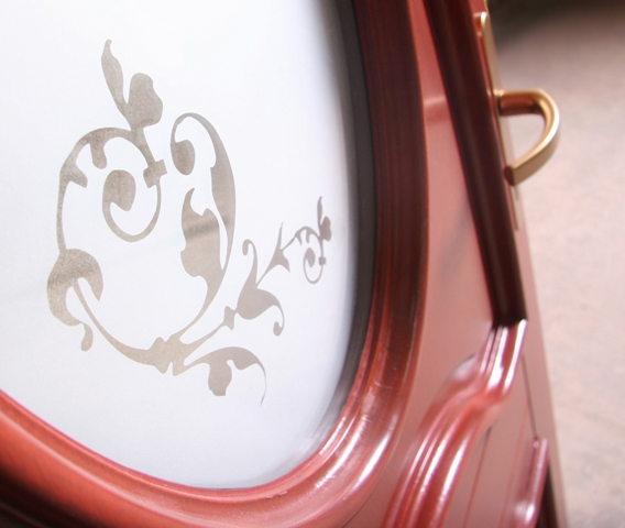 Fragment mebla z dekoracyjnym, florystycznym motywem na szklanym panelu i mosiężnym uchwytem, wykonany na indywidualne zamówienie w Trzciance.