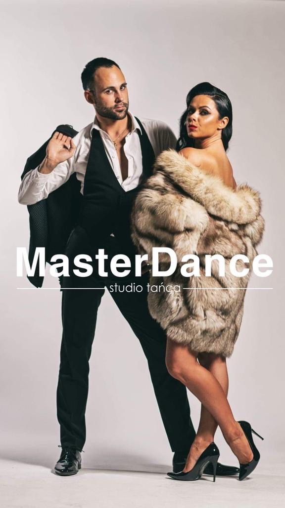 Elegancka para w pozach tanecznych na jasnym tle: mężczyzna w garniturze z marynarką na ramieniu, kobieta w futrze i szpilkach, z widocznym logo studia.