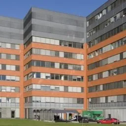 Nowoczesny budynek biurowy z roletami zewnętrznymi w Tomaszowie Lubelskim, widok z zewnątrz w słoneczny dzień.