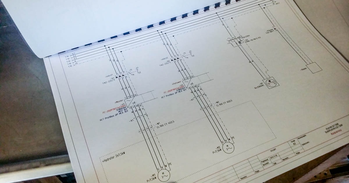 Schemat elektryczny automatyki, widoczne oznaczenia komponentów i połączeń, otwarty dokument na stole.