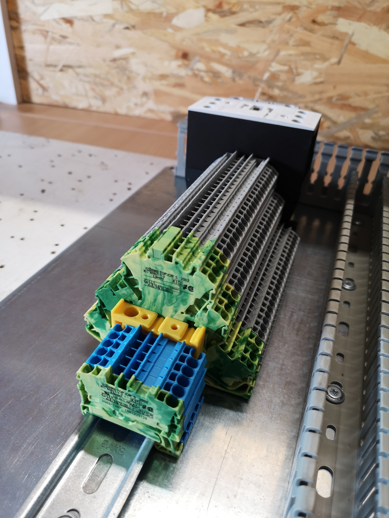 Zestaw złączek elektrycznych WAGO TOPJOB S 2002, kolorowe, na metalowej szynie DIN, widoczne oznaczenia i parametry na obudowie.