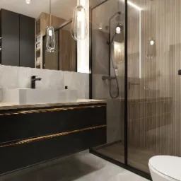 Nowoczesna łazienka z kabiną prysznicową, umywalką na szafce z czarnymi frontami i marmurową posadzką. Minimalistyczne oświetlenie i armatura.