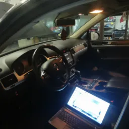 Diagnostyka komputerowa samochodu w Świedziebni: wnętrze pojazdu z otwartą maską, laptop podłączony do systemu, widoczny kokpit i kierownica.